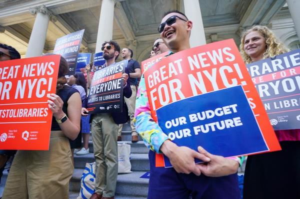 Mayor Eric Adams speaking to supporters outside City Hall, holding a small airplane symbol after discussing the NYC budget proposal for the 2025 fiscal year