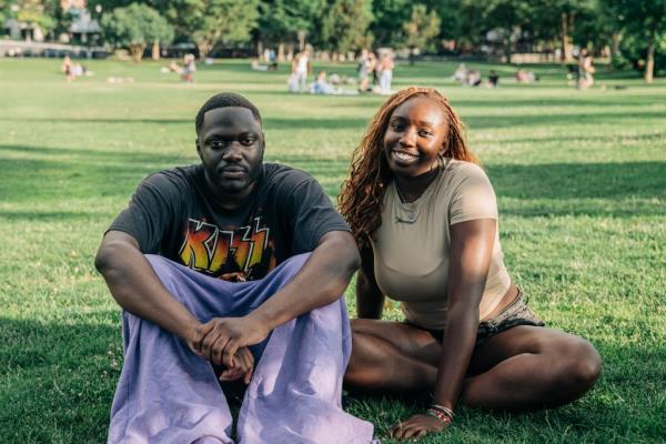 Moustapha Camara and Fatim Haitara sitting on grass in Manhattan, posing for a photograph