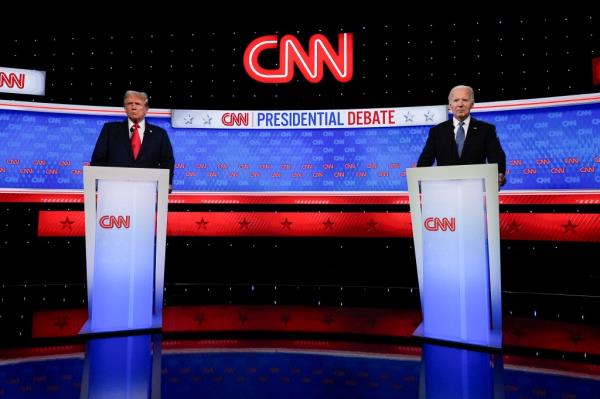 President Joe Biden and former President Do<em></em>nald Trump standing at podiums during a break in the 2024 presidential debate in Atlanta