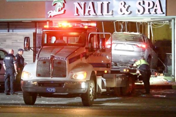 The vehicle that crashed into the salon is towed away.