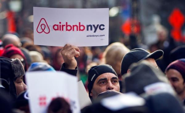 A crowd of supporters of Airbnb hold signs at a rally outside City Hall in New York on January 20, 2015